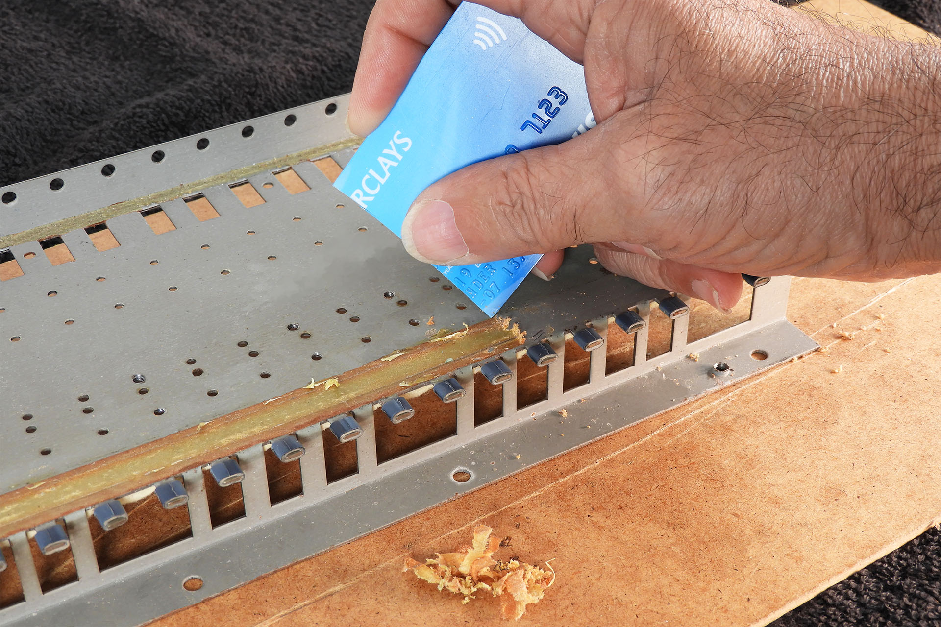 Removing glue from a JX-8P keyboard chassis with a credit card