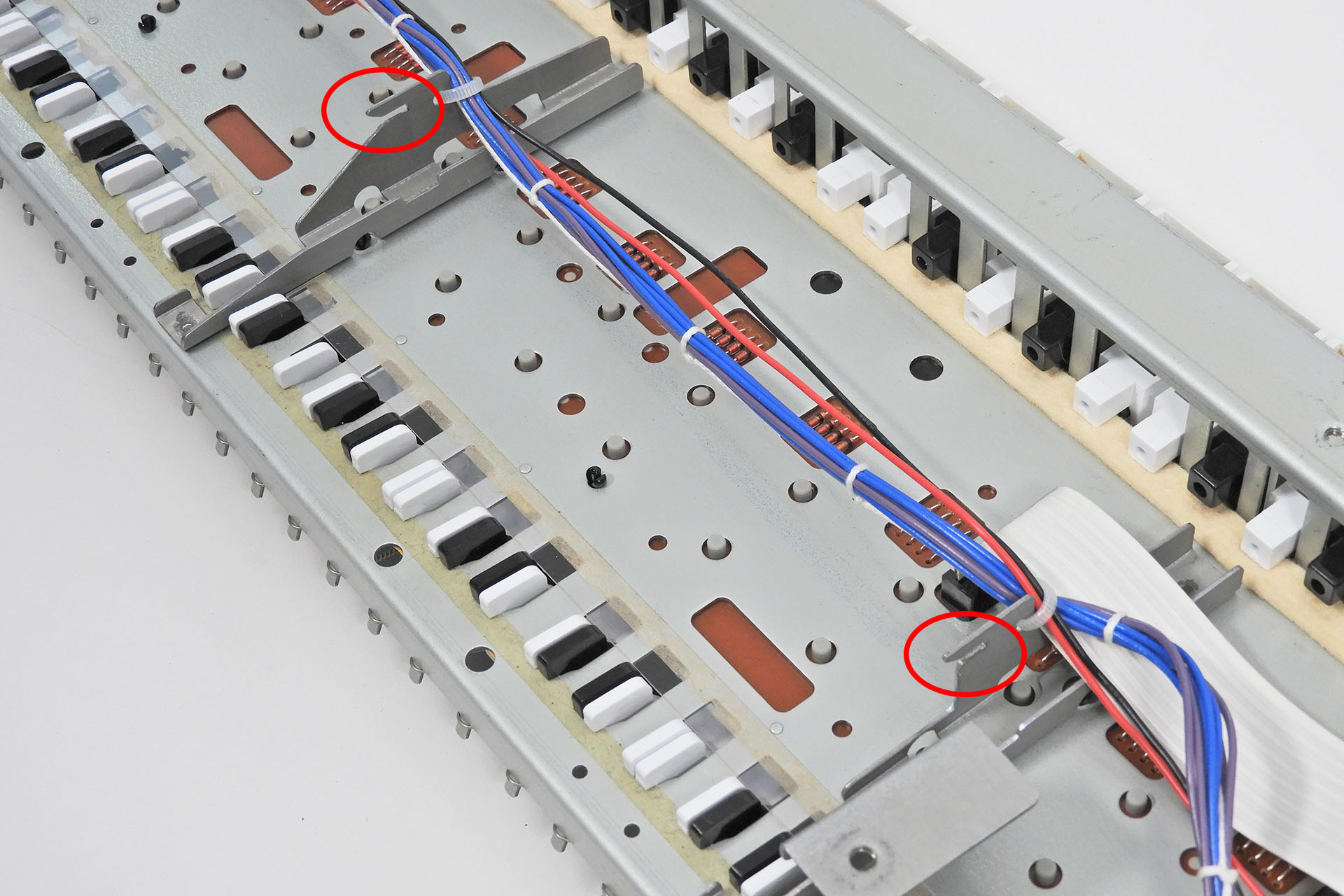 Slots in the keyboard chassis supports of the Roland Alpha Juno 2